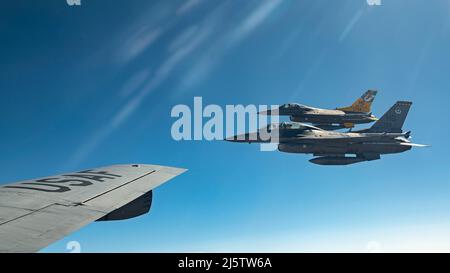 Zwei F-16 kämpfende Falcons fliegen in Formation, nachdem sie Treibstoff von einem KC-135 Stratotanker vom Luftwaffenstützpunkt Fairchild über New Mexico erhalten haben, 14. April 2022. Crews aus Fairchild unterstützten während einer Trainingsmission die Flugzeugbetankung, so dass die F-16-Crews ihre Einsatzbereitschaft aufrechterhalten konnten. (USA Luftwaffe Foto von Staff Sgt. Ryan Gomez) Stockfoto