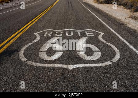 Route 66 Schild auf der rechten Fahrspur in der Wüste von Kalifornien gestrichen Stockfoto