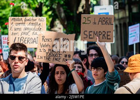 Porto, Portugal. 25. April 2022. Junge Demonstranten halten während der Parade Plakate. Die Parade vom 25.. April feiert die Nelkenrevolution, die 1974 stattfand. In Porto organisierten zivile Bewegungen eine Parade, die vor der inzwischen ausgestorbenen PIDE (politische Polizei) begann und direkt im Herzen der Stadt in der Avenida dos Aliados (Allies Avenue) endete. Kredit: SOPA Images Limited/Alamy Live Nachrichten Stockfoto