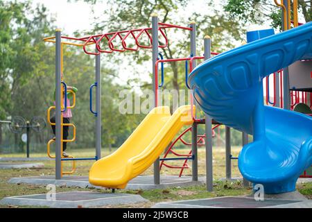 Spielgeräte für Kinder, im Freien, auf denen unbekanntes Kind spielt. Freizeit- oder Sommerkonzept. Stockfoto