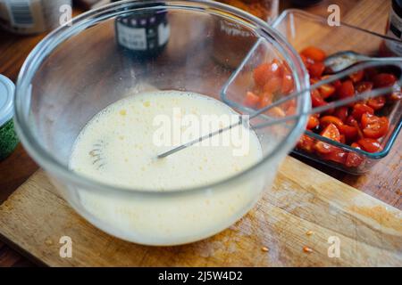 Prozess der Herstellung von hausgemachtem Omelett mit Käse und Tomaten. Stockfoto