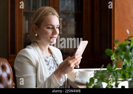 Porträt einer Geschäftsfrau, die mit einem Smartphone arbeitet. Stockfoto