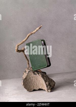 Grüner Ledereinband auf grauem Stein als Podium Stockfoto