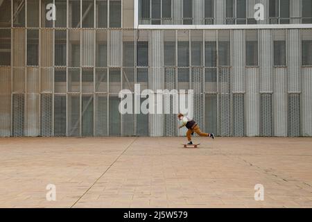 Moderner Mann, der auf einem Skateboard durch die Straßen der Stadt reitet Stockfoto