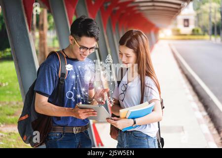 Junge Mann Student zeigt Informationen auf digitalen Tablet-Computer an eine Freundin, Männer zeigen Bibliothek zeigt etwas Interessantes in der Tablette, studyin Stockfoto