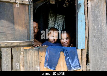 Eine madagassische Familie blickt aus ihrem Heimatfenster. Ambohimanga Region, Madagaskar. Stockfoto