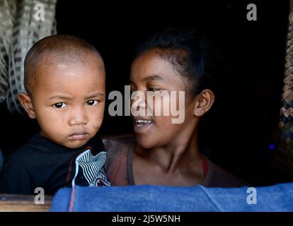 Eine madagassische Familie blickt aus ihrem Heimatfenster. Ambohimanga Region, Madagaskar. Stockfoto