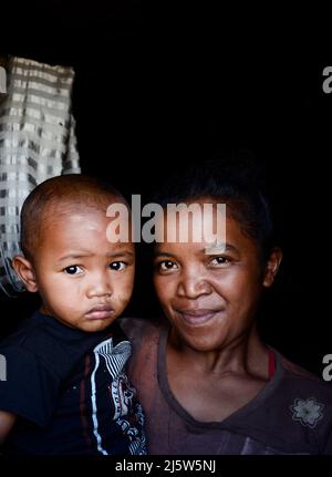 Eine madagassische Familie blickt aus ihrem Heimatfenster. Ambohimanga Region, Madagaskar. Stockfoto