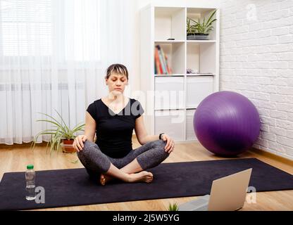 Junge sportliche Frau praktiziert Yoga. Konzept der Achtsamkeitsmeditation. Stockfoto