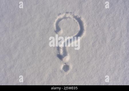 Fragezeichen auf weißem Neuschnee im Winter, Nahaufnahme. Fragezeichen auf Schnee natürliche Oberfläche, kopieren Raum Hintergrund Stockfoto