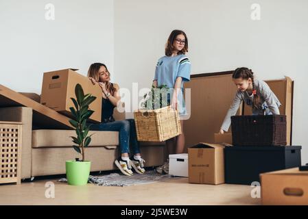 Familie packt Pappkartons in neuem Zuhause aus. Stockfoto