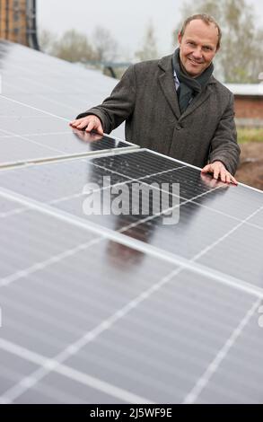 25. April 2022, Sachsen, Zwickau: Wolfram Günther (die Grünen), Sachsens Energie- und Klimaschutzminister, steht in einem neuen Solarpark. Die Enerparc AG betreibt den sechs Hektar großen Solarpark Mosel und wird in den nächsten 20 Jahren jährlich 5,5 Millionen kWh Solarenergie für die Produktion der vollelektrischen Volkswagen-Modelle aus Zwickau liefern. Alle drei Volkswagen-Standorte in Sachsen werden bereits seit Ende 2017 mit Ökostrom aus Wasserkraft versorgt. Bisher kam dies jedoch aus Österreich. Zwickau ist nun der erste sächsische Standort, der Solarenergie für die Fahrzeugproduktion erhält Stockfoto