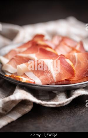 schwarzwald-Schinken in Scheiben geschnitten. Getrockneter Schinken auf einem Teller. Stockfoto
