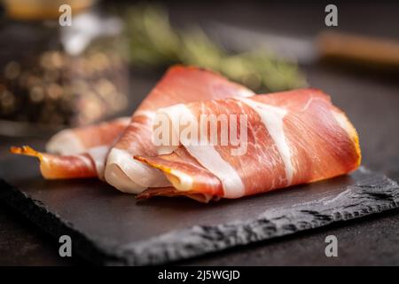 schwarzwald-Schinken in Scheiben geschnitten. Getrockneter Schinken auf einem Schneidebrett. Stockfoto