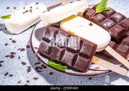 Schokolade- und Vanillepopsicles, klassischer dunkelbrauner Kakao und Milcheis-Lolly-Pops. Stapel von verschiedenen Eis-Lollies flach Draufsicht CO Stockfoto