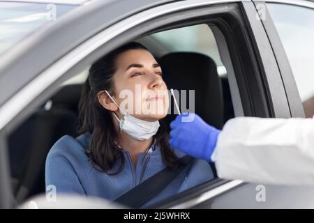 Mitarbeiter im Gesundheitswesen, die Coronavirus-Tests im Auto durchführen Stockfoto