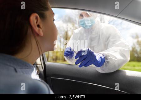 Mitarbeiter im Gesundheitswesen, die Coronavirus-Tests im Auto durchführen Stockfoto