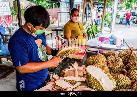 Bangkok, Thailand. 26. April 2022. Durian-Händler bereiten die Früchte für den Verkauf auf einem Outdoor-Markt vor. In Thailand beginnt die Durian-Saison. Die saisonalen Früchte sind eine Cash-Ernte für den nationalen und internationalen Export Thailands. Kredit: SOPA Images Limited/Alamy Live Nachrichten Stockfoto