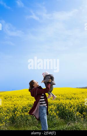 Ein Baby und ihre Mutter genießen einen sonnigen Tag auf dem Feld Stockfoto