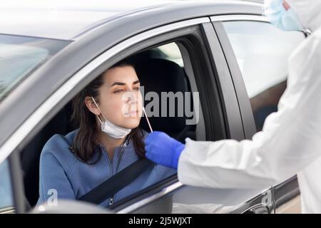 Mitarbeiter im Gesundheitswesen, die Coronavirus-Tests im Auto durchführen Stockfoto