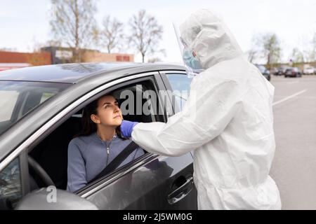Mitarbeiter im Gesundheitswesen, die Coronavirus-Tests im Auto durchführen Stockfoto