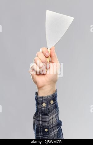 close up of builder's hand holding putty knife Stockfoto