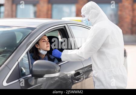 Mitarbeiter im Gesundheitswesen, die Coronavirus-Tests im Auto durchführen Stockfoto