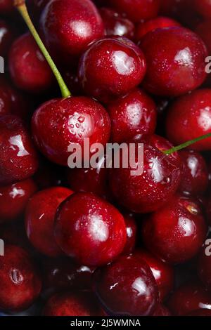 Nahaufnahme eines Pfahls von reifen Kirschen. Frische rote Kirschen. Reife Kirschen Hintergrund. Stockfoto