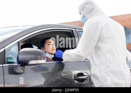 Mitarbeiter im Gesundheitswesen, die Coronavirus-Tests im Auto durchführen Stockfoto