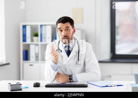 Männlicher Arzt mit Videokonferenz im Krankenhaus Stockfoto