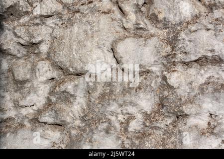Glatte Wand von alten Blöcken verschiedener Größen auf Mörtel. Stockfoto