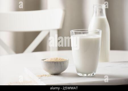 Sesammilch und Sesam in einer Schüssel auf weißem Küchenhintergrund. Laktosefrei. Nahaufnahme. Mangel an Cholesterin. Vitamine, Aminosäuren, Ballaststoffe, Mineralien Stockfoto