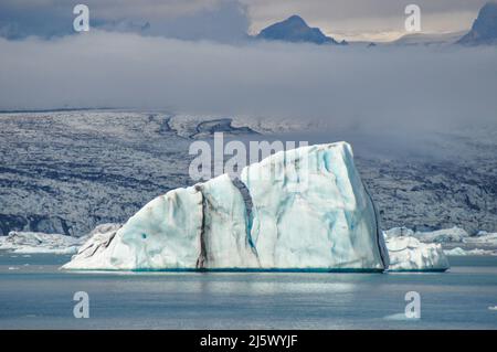 Eisberg in der Gletscherlagune Jökulsárlón, Südwest-Insel. Die schwarzen Linien im Eis sind Vulkanasche subglazialer brüche der Grímsvötn. Stockfoto