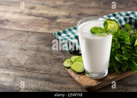 Ayran Drink mit Minze und Gurke im Glas auf Holztisch Stockfoto