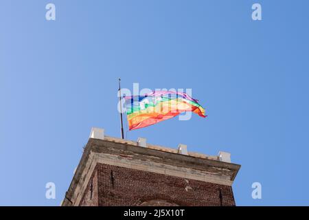 Regenbogenfahne mit dem Wort PACE Frieden auf Italienisch winkt auf dem Turm in Genua, Italien. Unterstützung des Ukraine-Konzepts Stockfoto