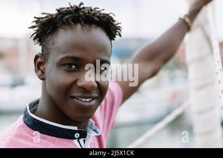 afroamerikanischer junger Mann, der im Sommer auf dem Boot steht Stockfoto