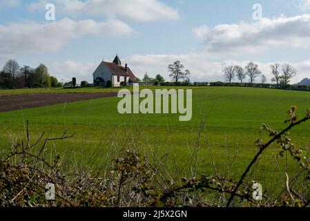 St. Huberts Kirche in Idsworth, Hampshire, England. Eine anglikanische Kirche aus dem 11.. Jahrhundert, die allein auf dem englischen Land steht. Stockfoto