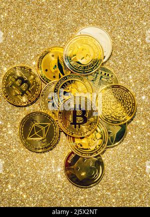 Goldene Krypto-Münzen auf goldenem Hintergrund. Bitcoin Kryptowährung mit Altmünzen und Shitcoins. Hochwertige Fotos Stockfoto