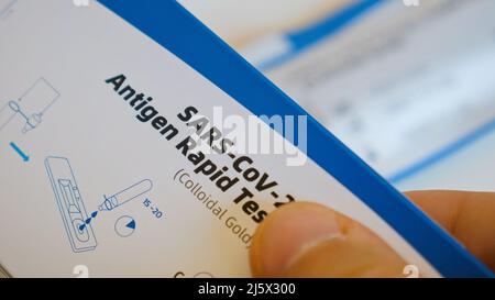 Nahaufnahme des Menschen untersucht Box mit SARS-Cov-2 Antigen Schnelltest mit Anweisung Stockfoto