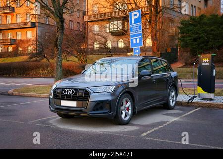 Audi Q7 60 TFSI e Plug-in Hybrid-Elektrofahrzeug, PHEV, Ladebatterie an der Seaside Helen Ladebuchse. Helsinki, Finnland. 10. April 2021. Stockfoto