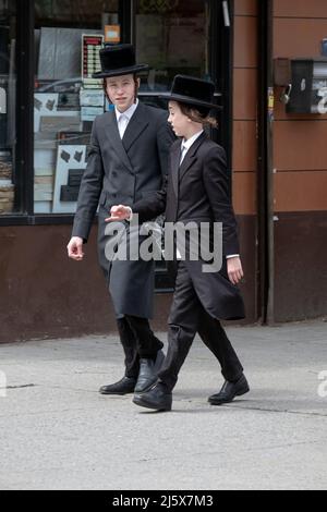 Zwei jüdische junge Männer mit langem Peyus laufen auf der Lee Avenue in Williamsburg, Brooklyn, New York City Stockfoto