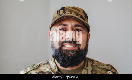 Veteran Soldat Mann lächelt auf Kamera während des Militärdienstes der Armee - Fokus auf Gesicht Stockfoto