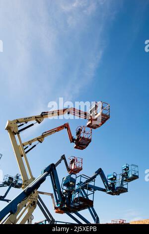 Cherry Picker silhouetted agaianst ein blauer Himmel auf einem Industriegebiet in der Nähe von Lincoln, Großbritannien.Mobile Elevating Work Platforms (MEWPs), oder auch bekannt als Stockfoto