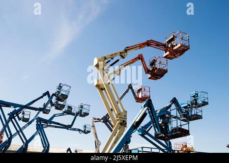 Cherry Picker silhouetted agaianst ein blauer Himmel auf einem Industriegebiet in der Nähe von Lincoln, Großbritannien.Mobile Elevating Work Platforms (MEWPs), oder auch bekannt als Stockfoto