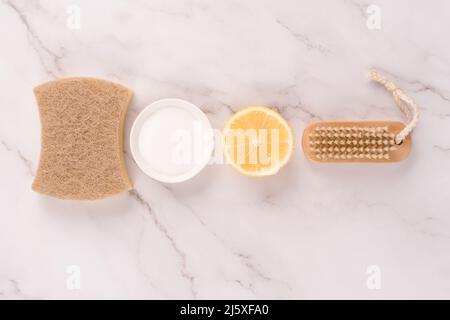 Flat Lay Zusammensetzung mit natürlichen Haushaltsreiniger Kit mit Öko-Zutaten - Bambusbürste, Zitrone, Backpulver, Zitronensäure auf Marmor Hintergrund. Gr Stockfoto