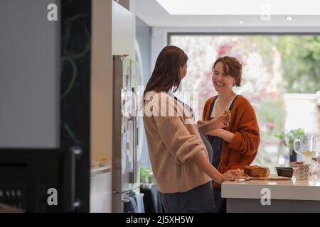 Glückliche Freundinnen essen Kuchen in der Küche Stockfoto