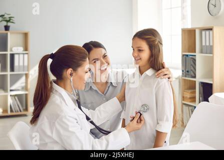 Ärztin Kinderärztin mit Stethoskop hört Lunge und Herz des Kindes Mädchen. Stockfoto