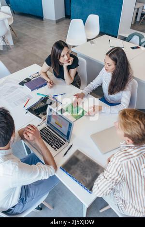 Menschen, die am Tisch sitzen, Kollegen, die im Büro arbeiten. Stockfoto