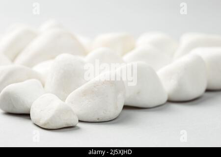 Weißer Felsen auf grauem Hintergrund. Dekorativer Stein Naturmaterial Stockfoto