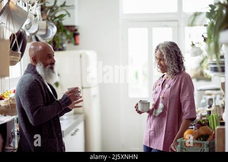 Seniorenpaar trinkt Kaffee und redet in der Küche Stockfoto
